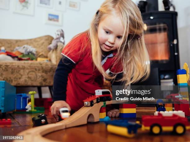 little girl playing with blocks and little train at home. - school railings stock pictures, royalty-free photos & images