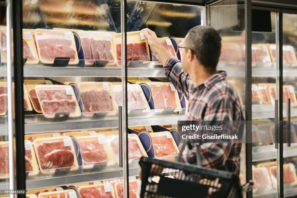 Mann kauft Fleisch im Supermarkt