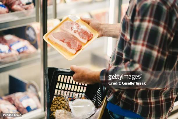 man shopping in the butchery section of a supermarket - meat packaging stock pictures, royalty-free photos & images