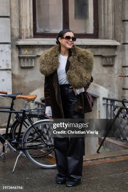Darja Barannik wears brown blazer with green faux fur scarf, black pants, sunglasses Loewe outside Aeron during the Copenhagen Fashion Week AW24 on...