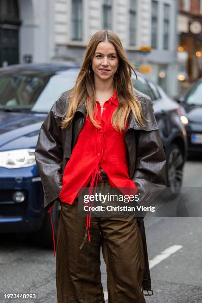 Trine Kjaer wears red blouse, brown wide leg pants, leather jacket outside Aeron during the Copenhagen Fashion Week AW24 on January 30, 2024 in...