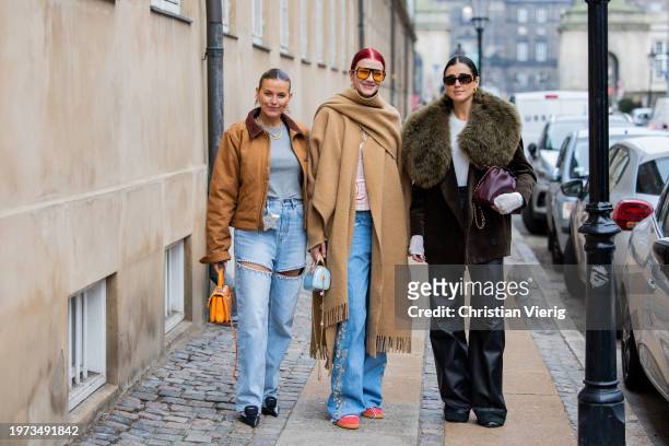 Janka Polliani wears brown jacket, ripped denim jeans, orange Chanel bag, grey shirt & Marianne Theordorsen wears beige coat & Darja Barannik wears...