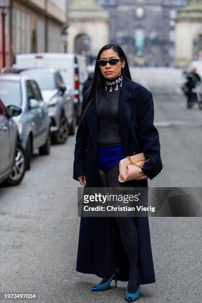 Miki Cheung wears navy coat, salmon colored bag, navy micro shorts, grey shirt, necklace outside Lovechild 1979 during the Copenhagen Fashion Week...