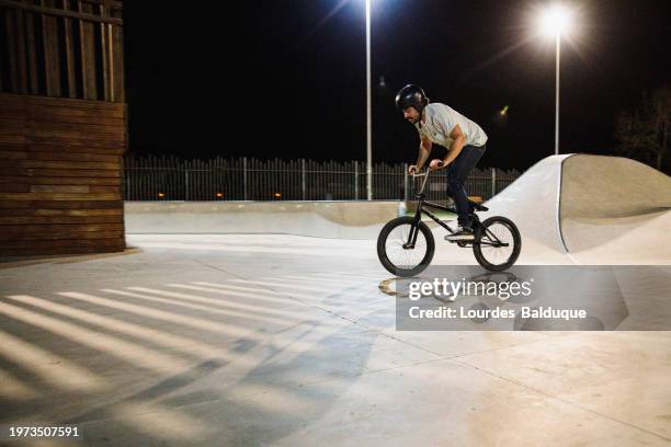 bmx rider trying to land trick - wheelie stock pictures, royalty-free photos & images