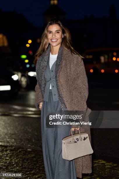 Guest wears brown coat, grey pants outside Remain during the Copenhagen Fashion Week AW24 on January 30, 2024 in Copenhagen, Denmark.