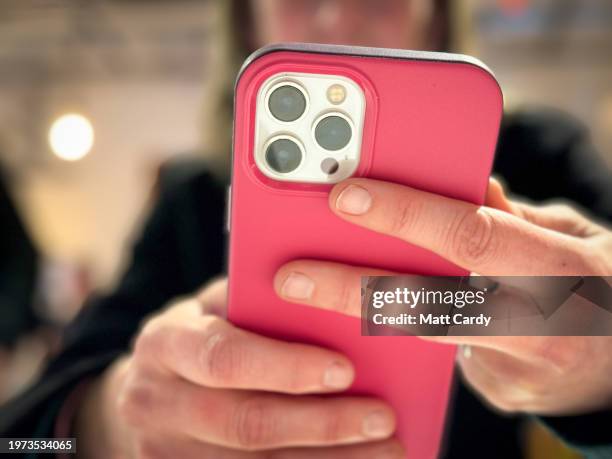 Woman looks at a iPhone screen on January 26, 2024 in Bath, England. The amount of time children spend on screens each day rocketed during the Covid...