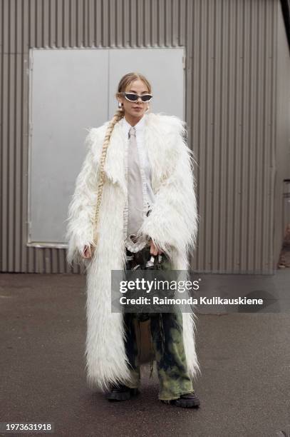 Guest wears green pants, a white shirt, a grey tie with cut out heart, and an army green bag outside Vain during the Copenhagen Fashion Week AW24 on...