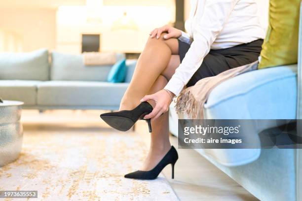 low section view of adult woman with crossed legs take off her high heels - stiletto ストックフォトと画像