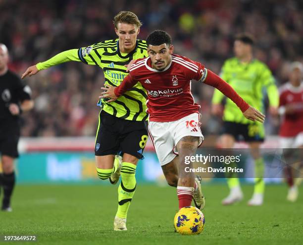 Martin Odegaard of Arsenal closes down Morgan Gibbs-White of Forest during the Premier League match between Nottingham Forest and Arsenal FC at City...