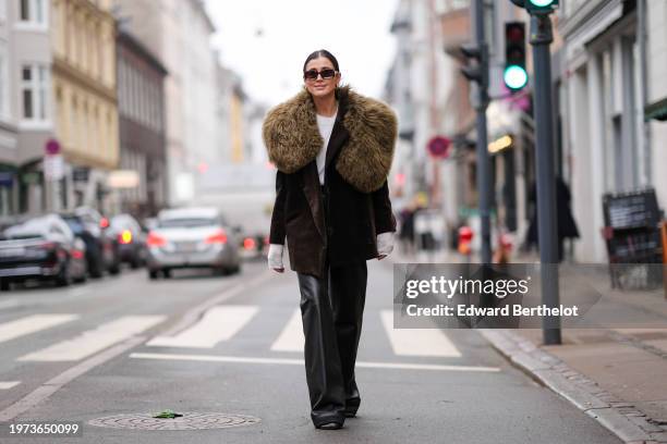 Darja Barannik wears sunglasses, a khaki oversized blazer jacket with fluffy faux fur parts, black leather flared pants, outside Aeron, during the...