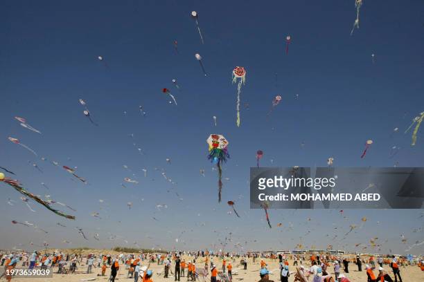 Palestinian children fly kites along the beach during a UN-sponsored summer camp in Gaza City on July 30, 2009. Thousands of children in the Gaza...