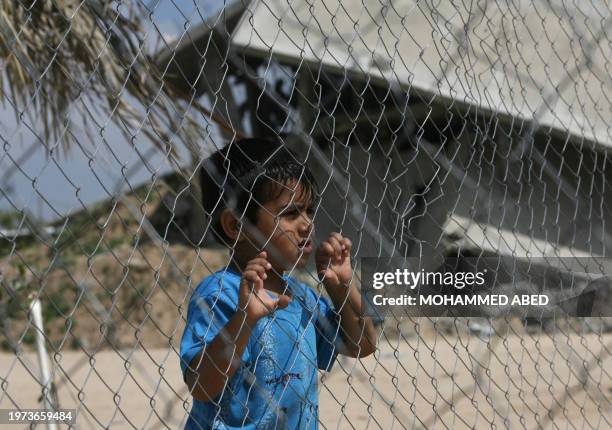 Palestinian boy looks out through a fence in the Jabalia refugee camp in the northern Gaza Strip on April 8, 2009. A week after a largely right-wing...