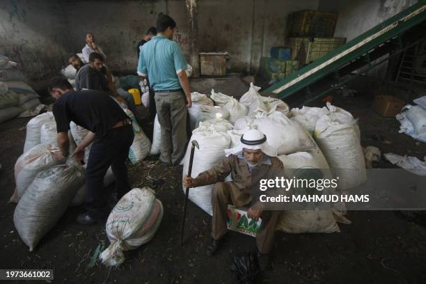 An elderly Palestinian man waits at an olive oil factory following a harvest in Gaza City on October 6, 2008 at the start of the harvesting season....