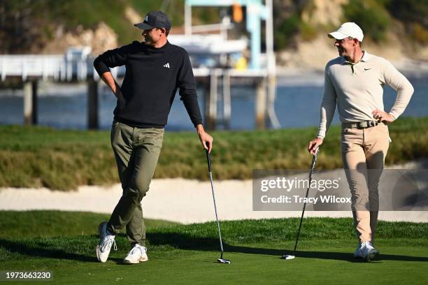 Rory McIlroy of Northern Ireland and Ludvig Åberg of Sweden stand on the 17th green during the second round of AT&T Pebble Beach Pro-Am at Pebble...