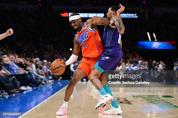 Shai Gilgeous-Alexander of the Oklahoma City Thunder attempts to drive past Nick Smith Jr. #8 of the Charlotte Hornets during the second half at...