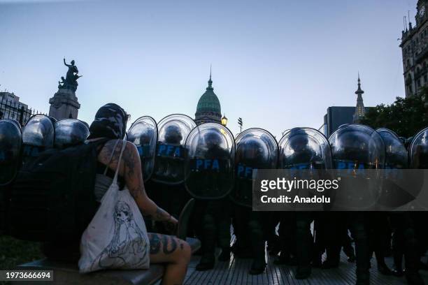 Police officers stand guard as demonstrators gather for a protest while the sessions in the national congress of Argentina where the 'Omnibus Law'...