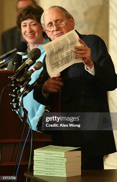 Senator Carl Levin reads a note to the media as U.S. Senator Susan Collins looks on at a media conference on the release of McCarthy era records on...