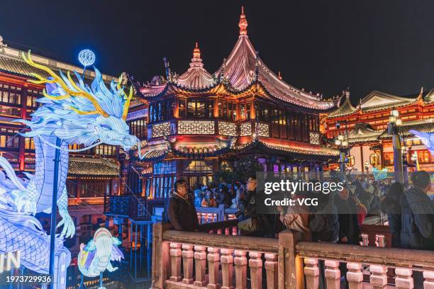 Tourists take photos in front of a dragon-shaped lantern at the Yuyuan Garden Lantern Show ahead of Chinese New Year, the Year of the Dragon, on...