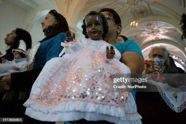 Resident of Candelaria Coyoacan, Mexico City, is carrying the image of the Child God into a church during mass and celebration on the occasion of...