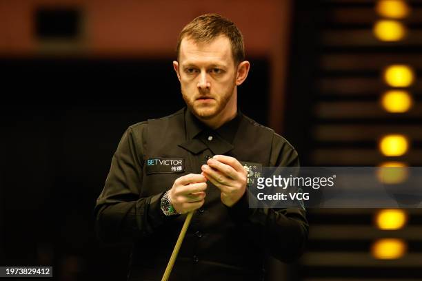 Mark Allen of Northern Ireland chalks the cue in the match against Louis Heathcote of England on day two of 2024 BetVictor German Masters at...