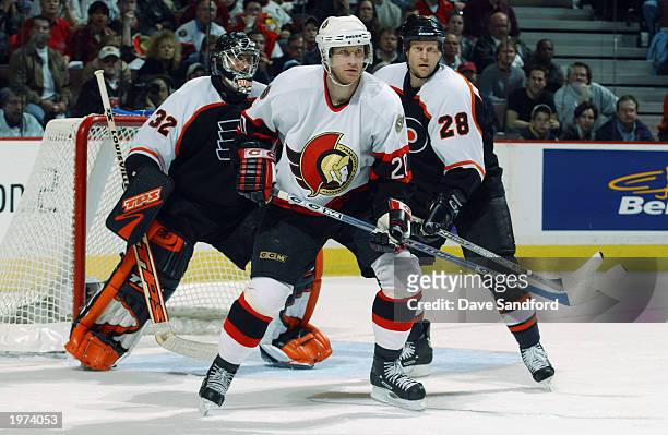 Magnus Arvedson of the Ottawa Senators positions himself in front of goaltender Roman Cechmanek of the Philadelphia Flyers as Marcus Ragnarsson helps...
