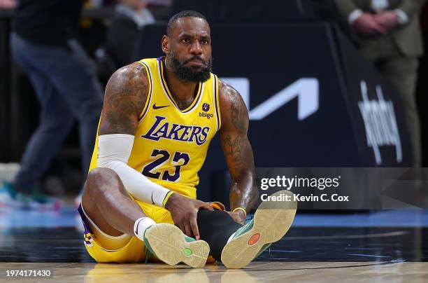 LeBron James of the Los Angeles Lakers holds his knee after falling against the Atlanta Hawks during the third quarter at State Farm Arena on January...