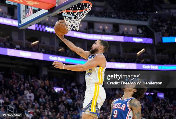 Stephen Curry of the Golden State Warriors goes in for a layup over Kelly Oubre Jr. #9 of the Philadelphia 76ers during the fourth quarter at Chase...