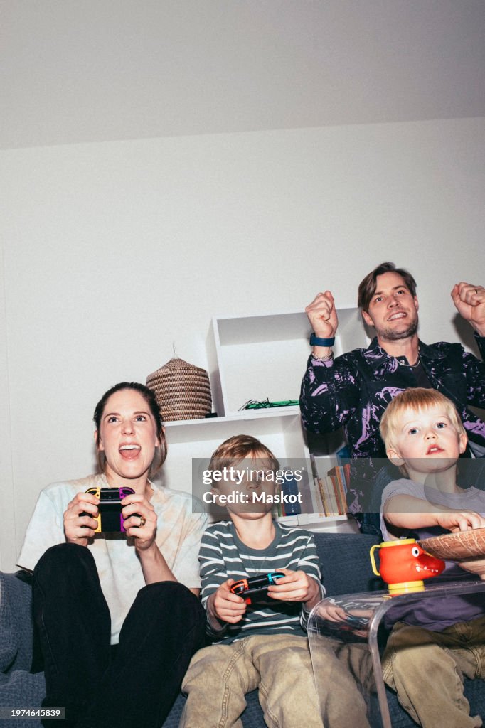 Happy family enjoying while playing video game at home