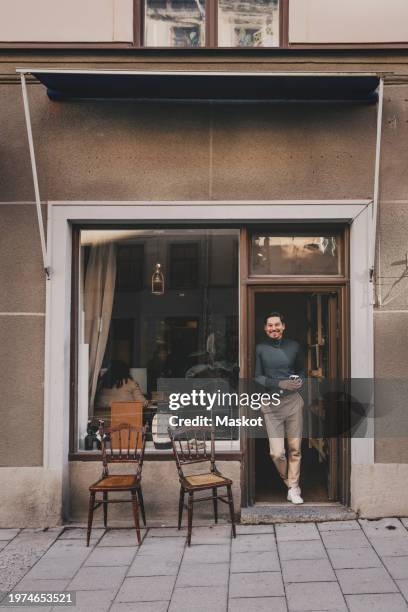 male business professional standing near office doorway - small office building exterior stock pictures, royalty-free photos & images