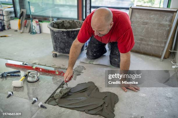 construction worker laying floor tiles - smooth stock pictures, royalty-free photos & images