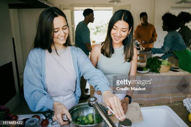 happy female friends preparing dinner together in kitchen at home - cleaning up after party stock pictures, royalty-free photos & images