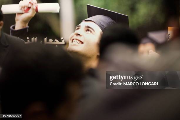 Palestinian students from the Gaza Strip walk pass a billboard advertising a distant learning program on November 4, 2009 at the Palestine...