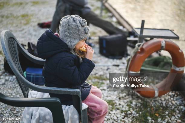 child eating sandwich on a river bank. - fly casting stock pictures, royalty-free photos & images