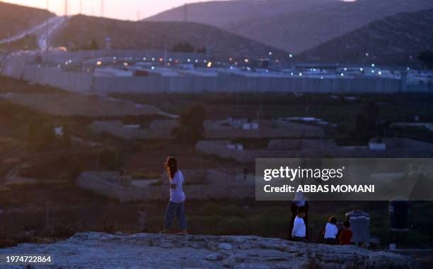 Relatives of Palestinian prisoners held in Israeli jails look at Ofer prison during an organised iftar meal after a day-long Ramadan fast in the West...