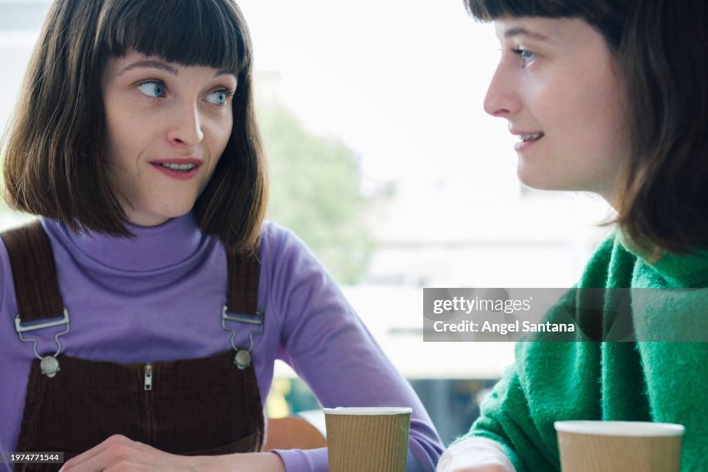 Two Friends Engaging in Conversation at Cafe