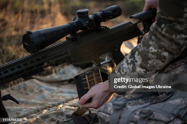 Ukrainian soldier load magazine to sniper rifle during training shootings at outdoor firing range on December 23, 2023 in Donetsk Oblast, Ukraine....