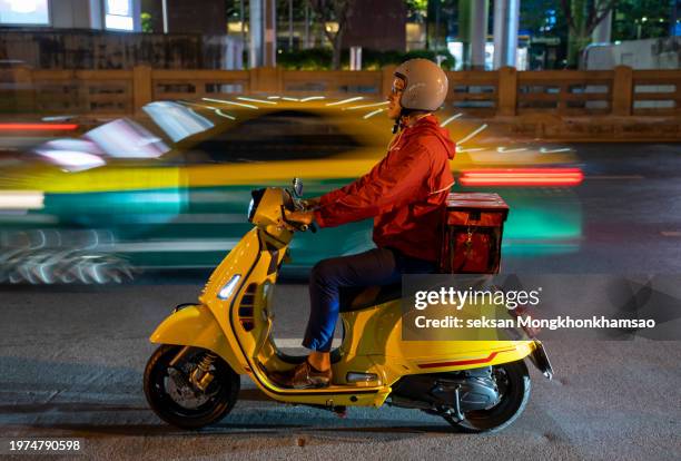 delivery man driving a scooter - motor scooter delivery stock pictures, royalty-free photos & images