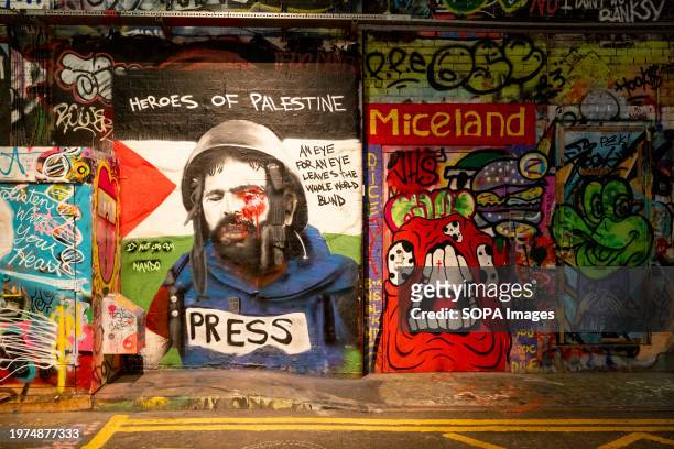Graffiti seen at Leake Street, the famous graffiti tunnel in central London, painted by street artist Nando, depicting Palestinian photojournalist,...