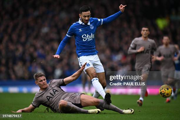 Tottenham Hotspur's Dutch defender Micky van de Ven challenges Everton's English midfielder Dwight McNeil during the English Premier League football...