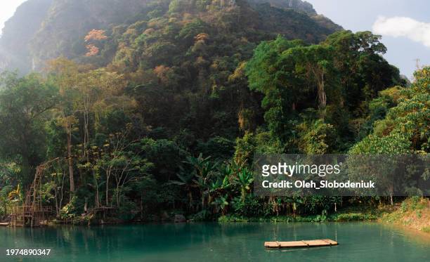 raft on idyllic blue lagoon in tropical setting - vang vieng stockfoto's en -beelden