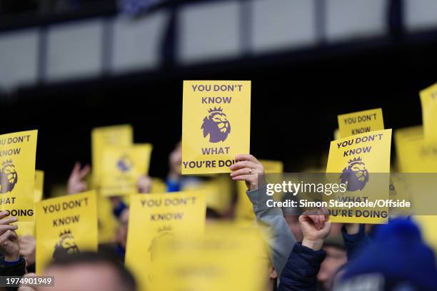 Everton fans hold up protest leaflets during the Premier League match between Everton FC and Tottenham Hotspur at Goodison Park on February 3, 2024...