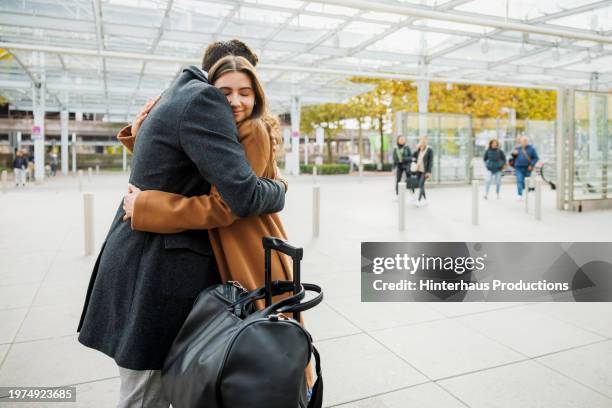 warm embrace outside airport - affectionate stock pictures, royalty-free photos & images