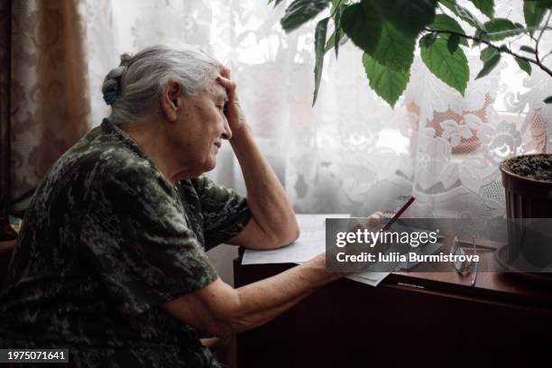 old lonely woman about to cry after seeing bills to pay. - só uma mulher idosa imagens e fotografias de stock