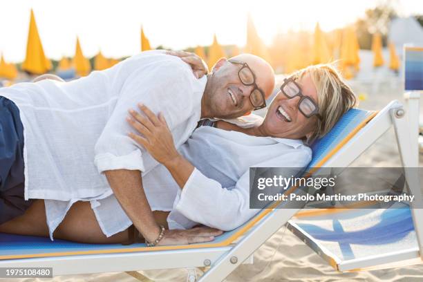 couple lying on beach lounger, smiling - chinese collar stock pictures, royalty-free photos & images