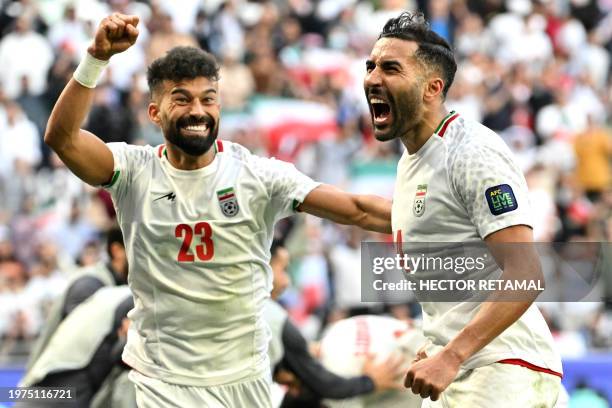Iran's defender Ramin Rezaeian and midfielder Saman Ghoddos celebrate their team's second goal during the Qatar 2023 AFC Asian Cup quarter-final...