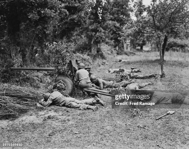 American soldiers of an anti-tank company from the 9th Infantry Division, VII Corps, United States First Army, fire a M1 57mm anti­tank gun from the...