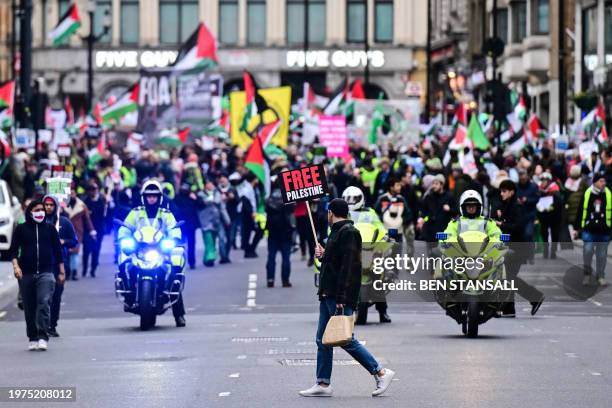 Pro-Palestinian activists and supporters wave flags and carry placards during a National March for Palestine in central London on February 3, 2024....