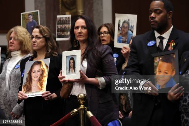 Audience members hold photos of loved ones during a Senate Judiciary Committee hearing at the Dirksen Senate Office Building on January 31, 2024 in...