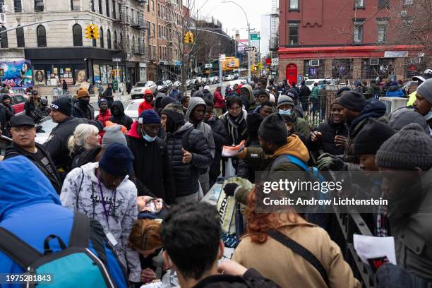 Single migrant men, mostly from West Africa, congregate in Tompkins Square Park as volunteers give away food and clothing, January 27 in the East...