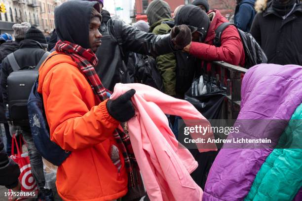 Single migrant men, mostly from West Africa, congregate in Tompkins Square Park as volunteers give away food and clothing, January 27 in the East...